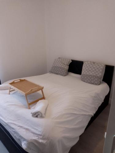 - un grand lit blanc avec un plateau en bois dans l'établissement Appartement avec 2 chambres Morlaix, à Morlaix