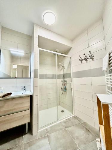 une salle de bain avec douche et lavabo dans l'établissement La terrasse de Deauville, à Deauville