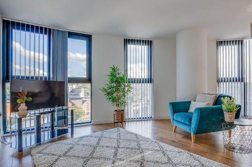 a living room with a blue chair and a tv at Blonk Street I Quarter Apartment in Sheffield