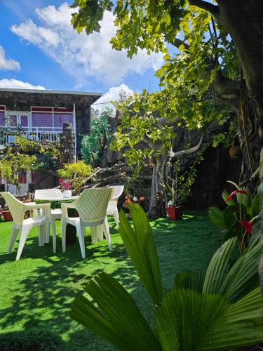 a patio with a table and chairs in a yard at S & B Dreams House in Munnar