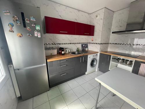 une cuisine avec un réfrigérateur en acier inoxydable et un évier dans l'établissement Appartement T3 proche Paris Stade de France, à Saint-Denis