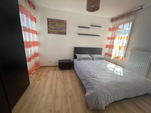 une chambre avec un lit et un parquet dans l'établissement Appartement T3 proche Paris Stade de France, à Saint-Denis