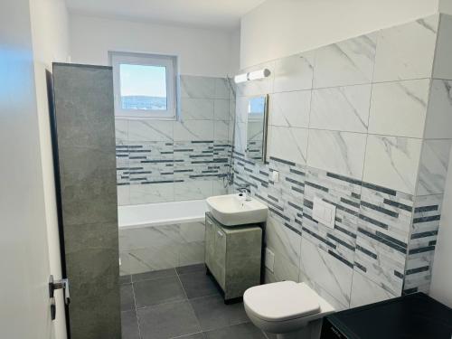 a white bathroom with a sink and a toilet at Milan Luxury Apartaments VII-Târgu Mureș#Maurer Residence in Târgu-Mureş