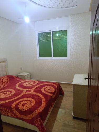 a bedroom with a bed and a window at Appartement tradimoderne in Mrhila