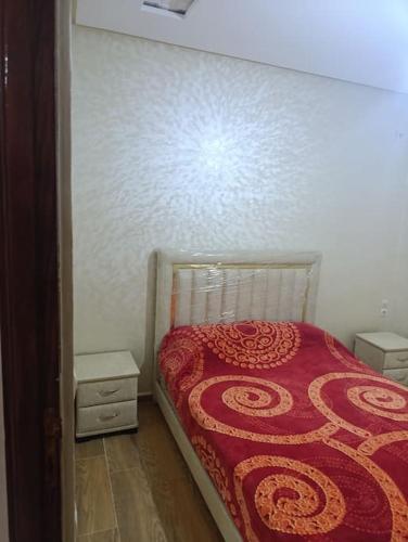 a small bedroom with a bed and two night stands at Appartement tradimoderne in Mrhila
