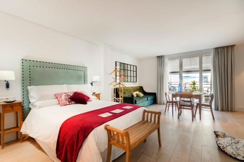 a bedroom with a large bed and a table at Apartamentos Turísticos La Plaza in Chipiona