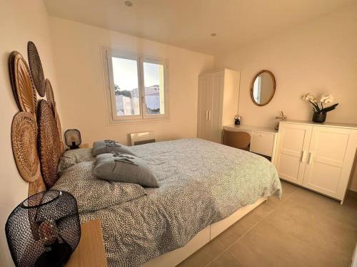 une chambre avec un grand lit et un miroir dans l'établissement Appartement T2 vue mer à Giens, à Hyères
