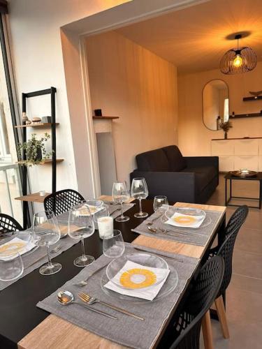 - une table à manger avec des verres à vin et des assiettes dans l'établissement Appartement T2 vue mer à Giens, à Hyères