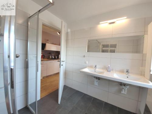 a white bathroom with two sinks and a shower at Alpine Tauplitz TOP 5 in Tauplitz