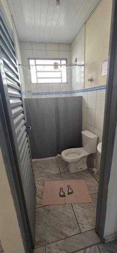 a bathroom with a toilet and a rug on the floor at Kit GT in São Carlos