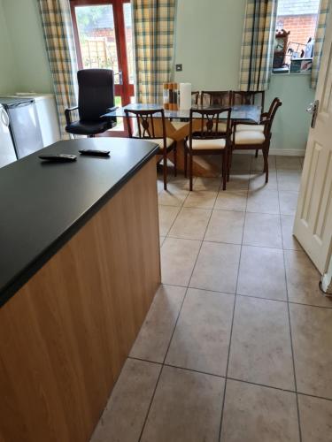 a kitchen with a counter and a table and chairs at 75 Park Prewett in Basingstoke