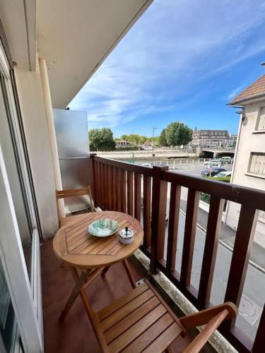 d'une petite table et d'une chaise en bois sur un balcon. dans l'établissement Studio hyper centre Trouville, à Trouville-sur-Mer