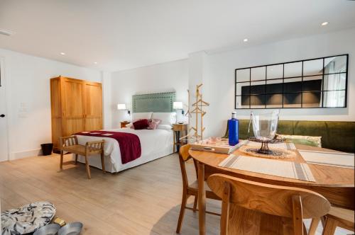 a bedroom with a bed and a table and a dining room at Apartamentos Turísticos La Plaza in Chipiona