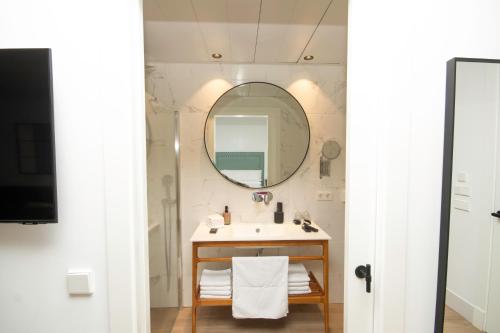 a bathroom with a sink and a mirror at Apartamentos Turísticos La Plaza in Chipiona