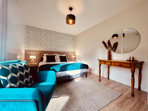 une chambre avec un lit, un canapé et un miroir dans l'établissement Appartement style chalet avec grande terrasse et parking prive, à Chamonix-Mont-Blanc