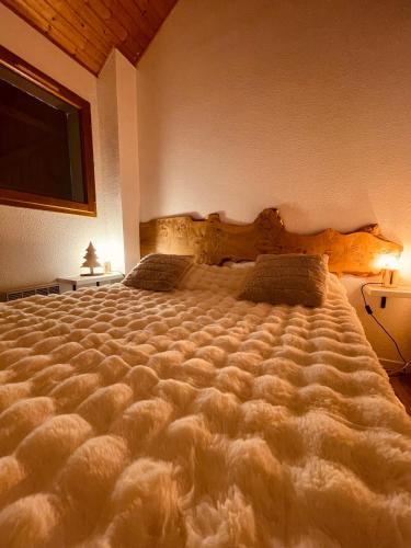a bedroom with a large bed with a large comforter at "La clé dorée" Chalet mitoyen avec jardin et -WIFI- in Cauterets