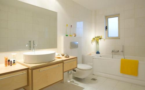 a bathroom with a sink and a tub and a toilet at Istron Maisonettes with private pool in Istron