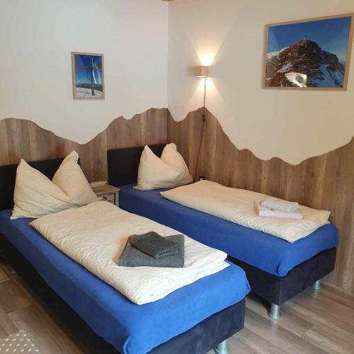 two beds in a room with blue and white at Ferienhaus Schäfer - Apartments - Wintersports - Family holiday - Holiday with your dog - Rural & Scenic in Flattnitz