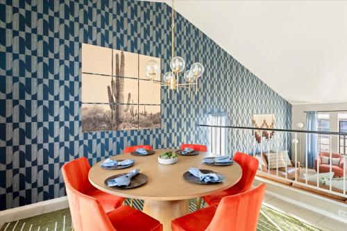 une salle à manger avec une table en bois et des chaises orange dans l'établissement Glendale Nights - Pool Hot Tub Put Put Foosball, à Glendale