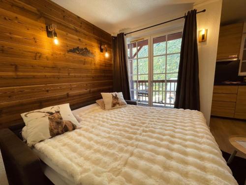 une chambre avec un grand lit avec un mur en bois dans l'établissement 