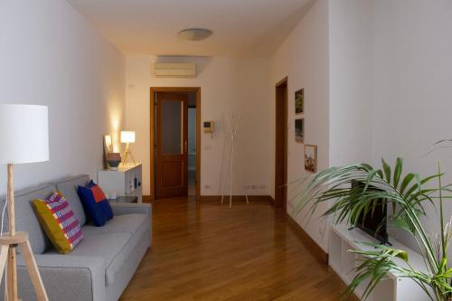 a living room with a couch and some plants at Appartamento moderno e tranquillo in Piacenza