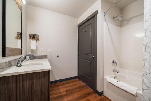 a bathroom with a sink and a mirror and a tub at The Lodge Lake Chelan in Manson