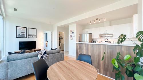 a living room and kitchen with a couch and a table at Stunning 1-Bedroom Condo in the Heart of Vancouver in Vancouver