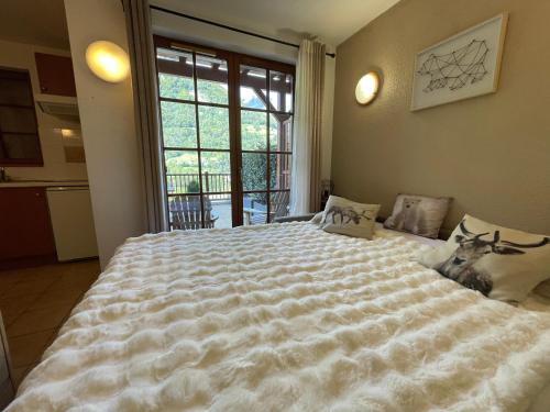 un grand lit blanc dans une chambre avec une fenêtre dans l'établissement 