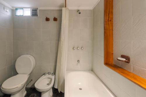 a bathroom with a toilet and a tub and a sink at Casas de alquiler Del Encuentro in San Martín de los Andes