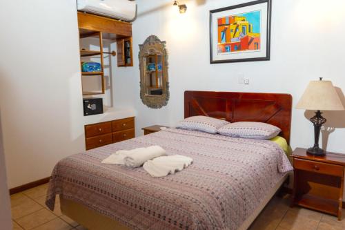 a bedroom with a bed with two towels on it at Apartotel Girasol in Jacó