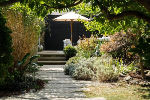 a patio with an umbrella in a garden at Kat Florence Hotels in Elora