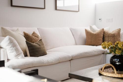 a living room with a white couch and pillows at Kat Florence Hotels in Elora