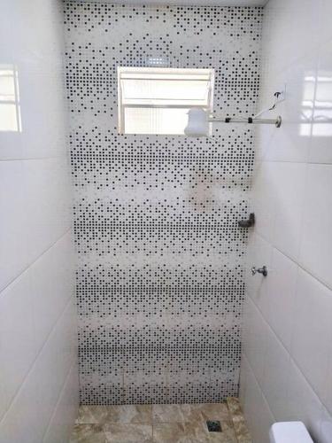 a bathroom with a shower with black and white tiles at Apartamento em Lins - apto 05 in Lins