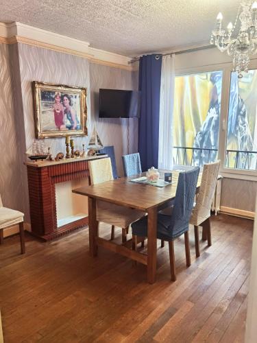 une salle à manger avec une table et des chaises en bois dans l'établissement Appartement Boulogne - Hyper centre, à Boulogne-sur-Mer