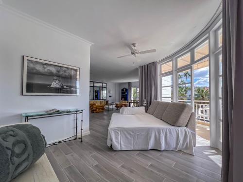 a white bedroom with a bed and a large window at Apartamentos Parque del Sol in Adeje