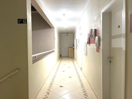 a hallway with a tile floor and a ceiling at Hotel Rosa da Ilha Guaruja - Perto do Mar com piscina in Guarujá