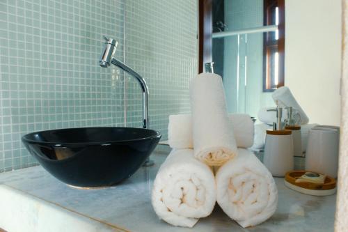 a bathroom with a sink and towels on a counter at Naquela Casa Jericoacoara in Jericoacoara