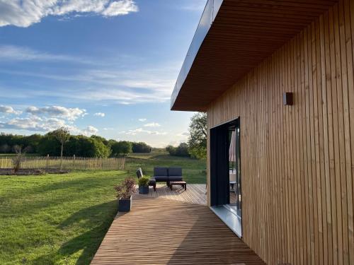 une terrasse en bois avec un banc à côté d'un bâtiment dans l'établissement Lodge évasion Lot & Dordogne, à Masclat