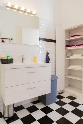 La salle de bains est pourvue d'un lavabo blanc et d'un sol noir et blanc. dans l'établissement Appartement avec vue 65m2 2Balcons 2Chambres VRAI CLIMATISATION, à Aix-en-Provence
