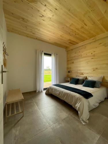 a bedroom with a large bed with a wooden ceiling at Lodge évasion Lot & Dordogne in Masclat