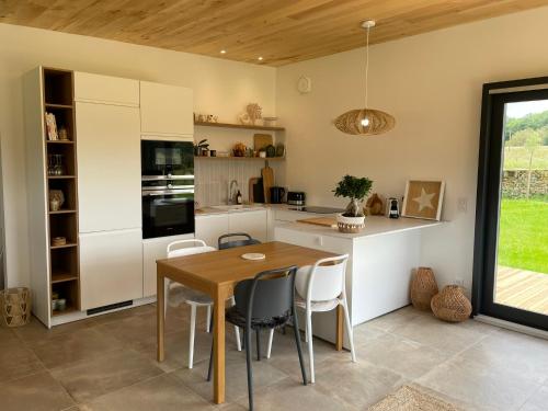 a kitchen and dining room with a table and chairs at Lodge évasion Lot & Dordogne in Masclat
