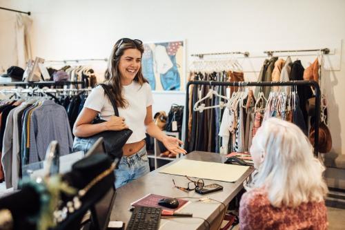 a woman standing in a clothing store talking to a customer at Maven STAY in Salt Lake City