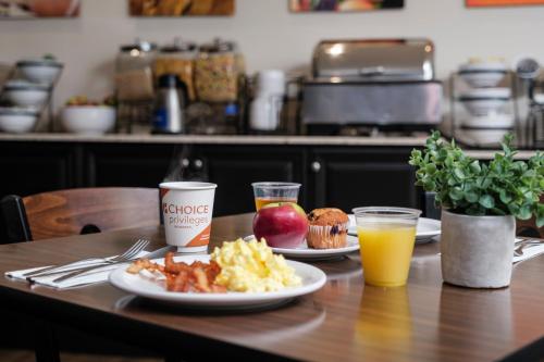 a table with two plates of breakfast food and orange juice at Comfort Inn - Gander in Gander