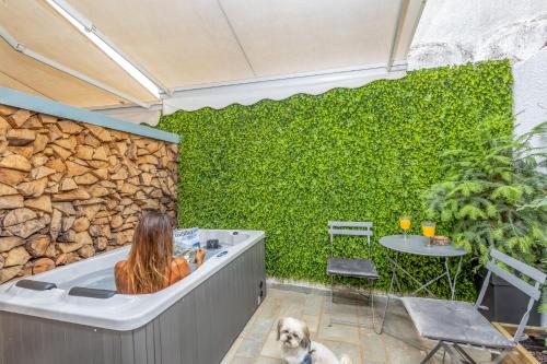 a woman sitting in a bath tub with a dog at Blue Mountain Guesthouse by Seablue in Arachova