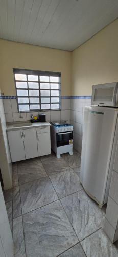 a kitchen with a stove and a refrigerator at Kit GT in São Carlos