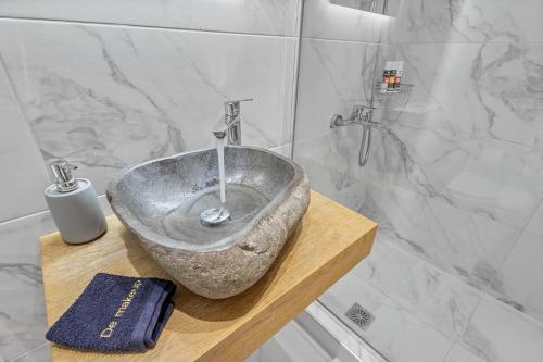 a bathroom with a stone sink on a wooden table at Blue Mountain Guesthouse by Seablue in Arachova