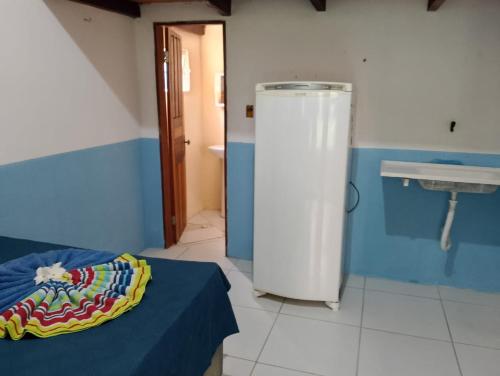a room with a bathroom with a sink and a bed at Chales do porto in Ilha de Boipeba