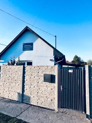 a building with a brick wall and a fence at Trendy House 65 in Karácsond