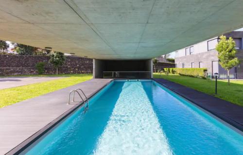 an overhead view of a swimming pool with blue water at Kame House - Gym & Sauna next to the Beach in Ponta Delgada
