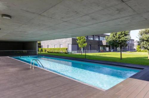 an empty swimming pool in a building with a building at Kame House - Gym & Sauna next to the Beach in Ponta Delgada